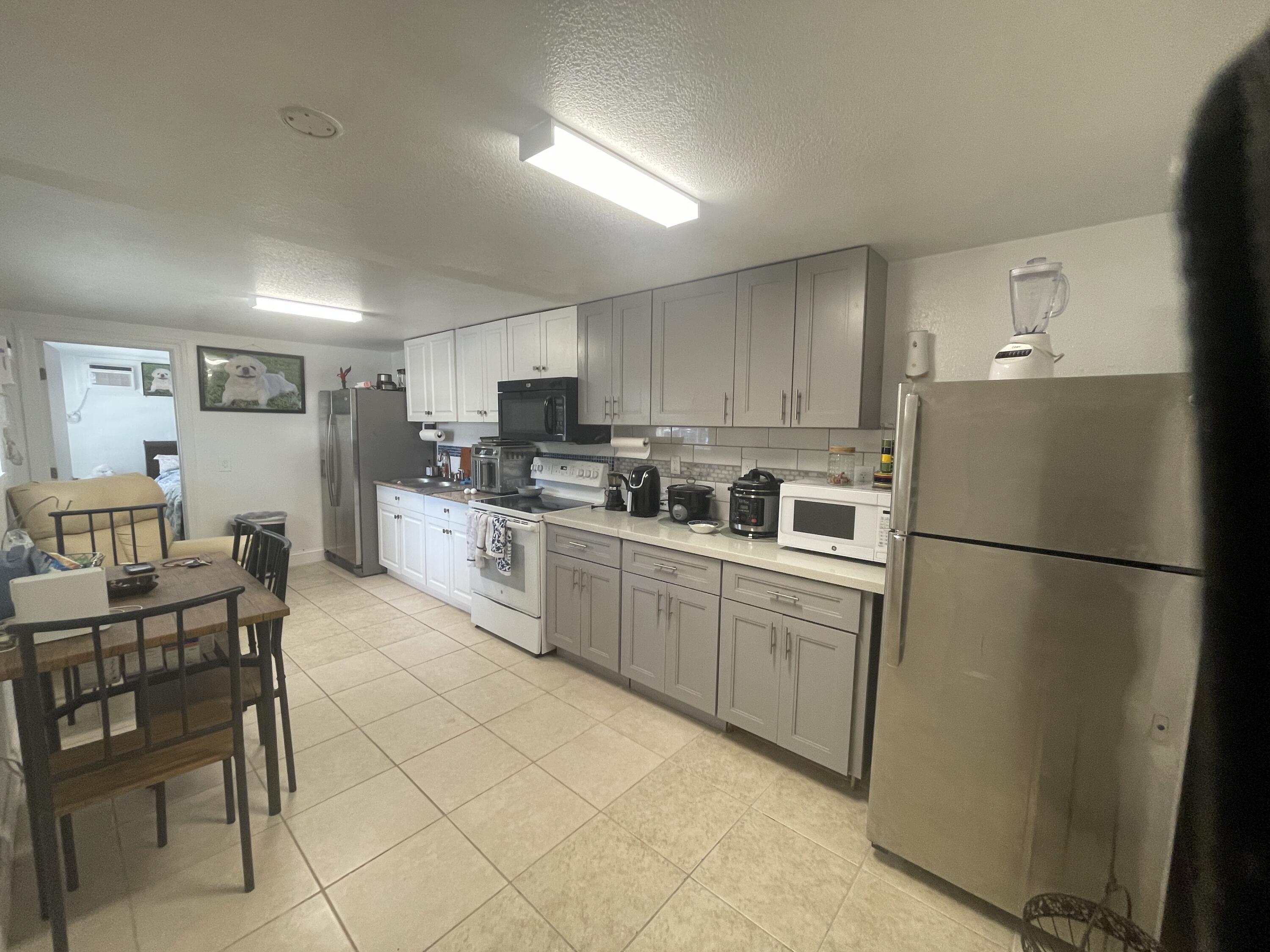 625 73rd Street, Unit AB Marathon, FL 33050 - Photo 4 of 23 a kitchen with a refrigerator a table and chairs in it