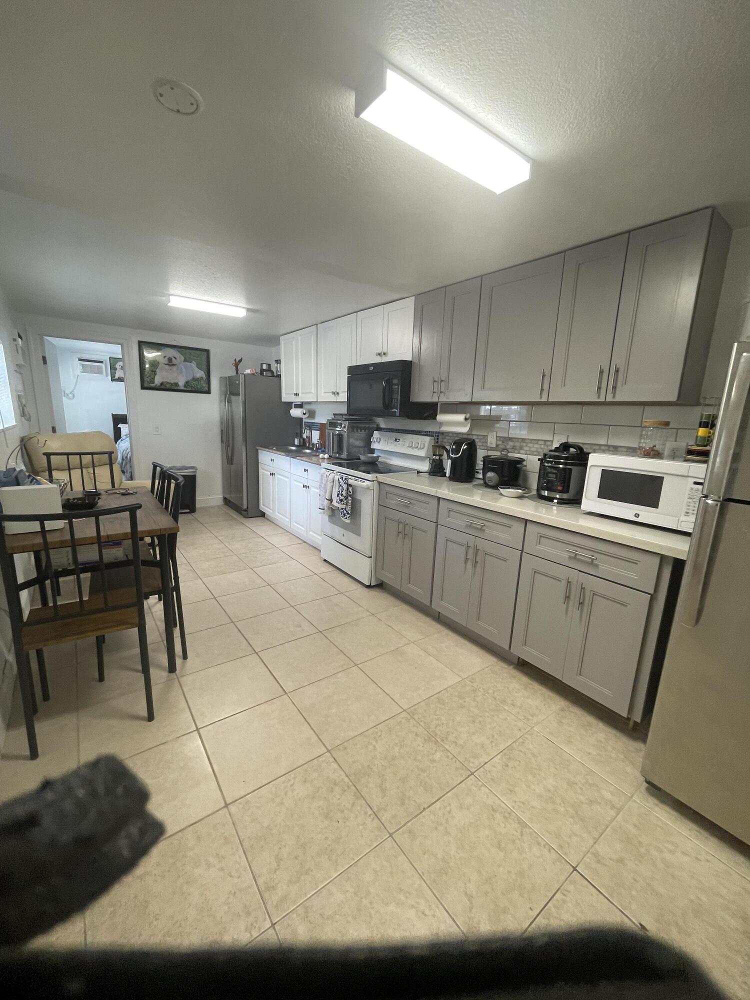 625 73rd Street, Unit AB Marathon, FL 33050 - Photo 5 of 23 a kitchen with stainless steel appliances a sink a stove a refrigerator cabinets and chairs