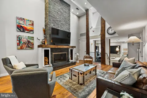 a living room with furniture a flat screen tv and a fireplace