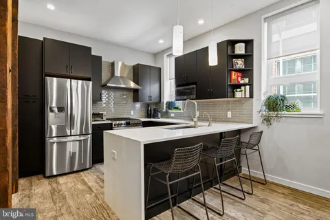 a kitchen with stainless steel appliances granite countertop a refrigerator and a stove top oven