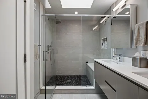 a bathroom with a shower sink and mirror