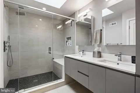 a bathroom with a shower sink and mirror