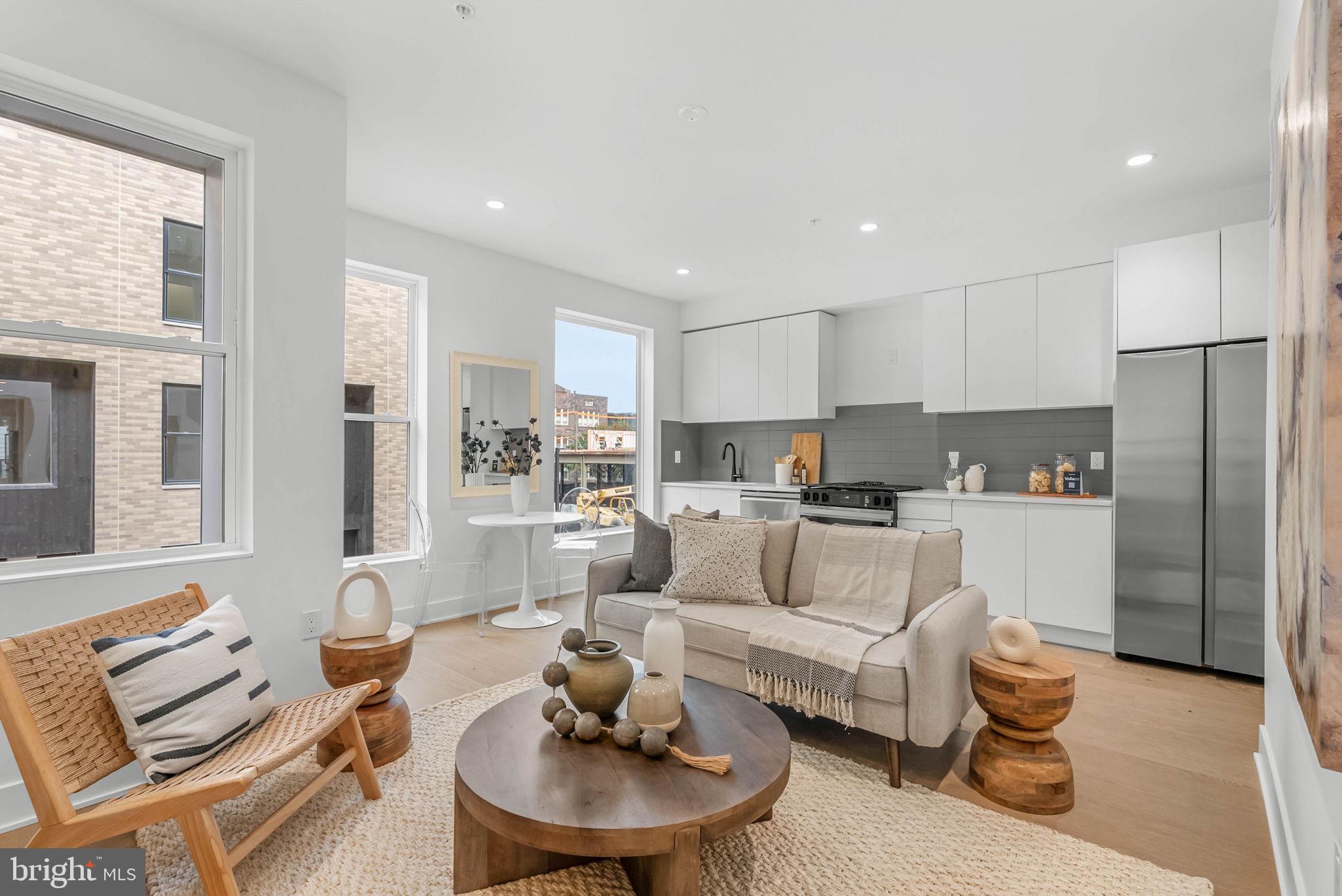 635 North 7th Street, Unit H2A Philadelphia, PA 19123 - Photo 1 of 25 a living room with furniture and a dining table with kitchen view