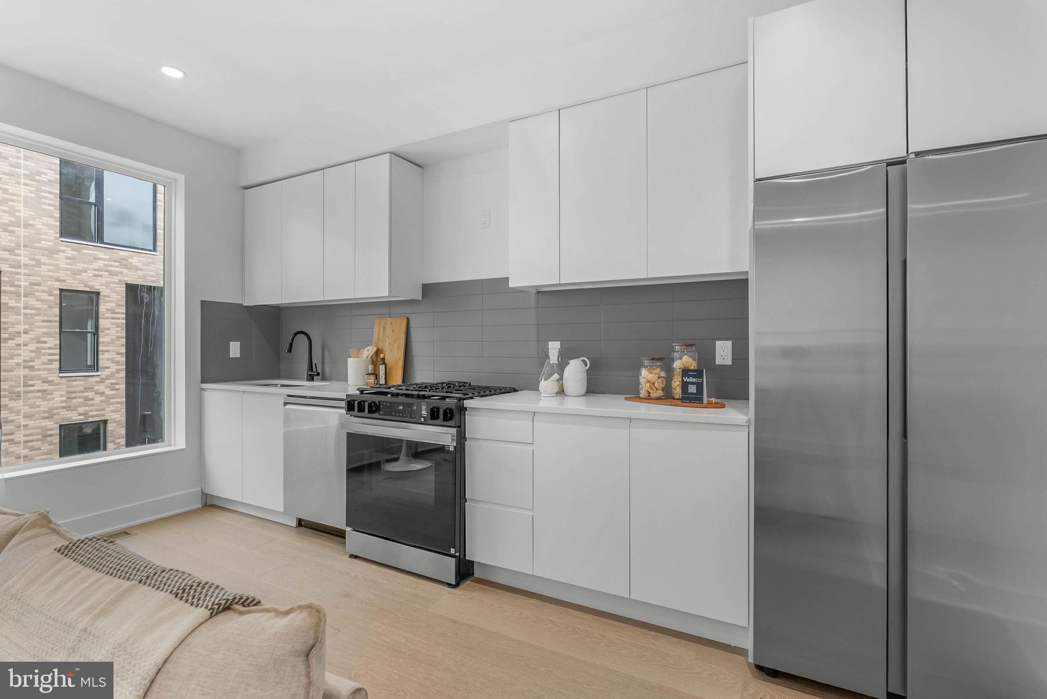 635 North 7th Street, Unit H2A Philadelphia, PA 19123 - Photo 3 of 25 a kitchen with white cabinets and white appliances