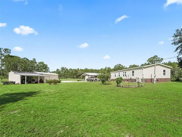 a view of a house with a yard and sitting area