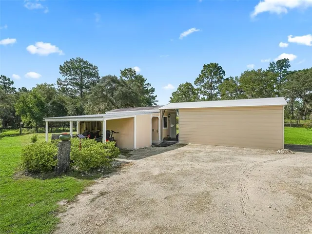 a view of a house with backyard and sitting area