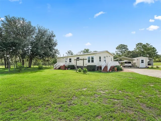 a view of a house with a yard and sitting area