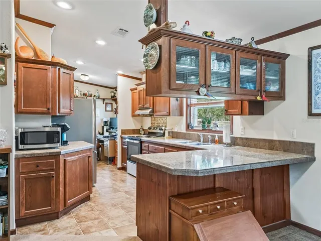 a kitchen with stainless steel appliances granite countertop a sink a stove and a microwave