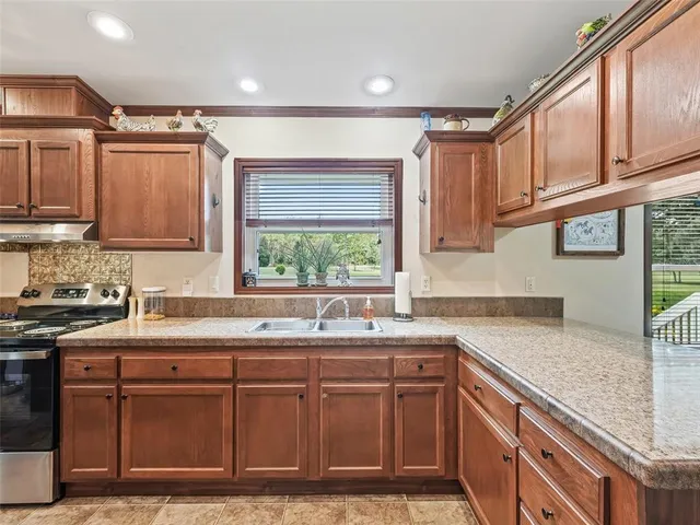a kitchen with stainless steel appliances granite countertop a sink stove and refrigerator