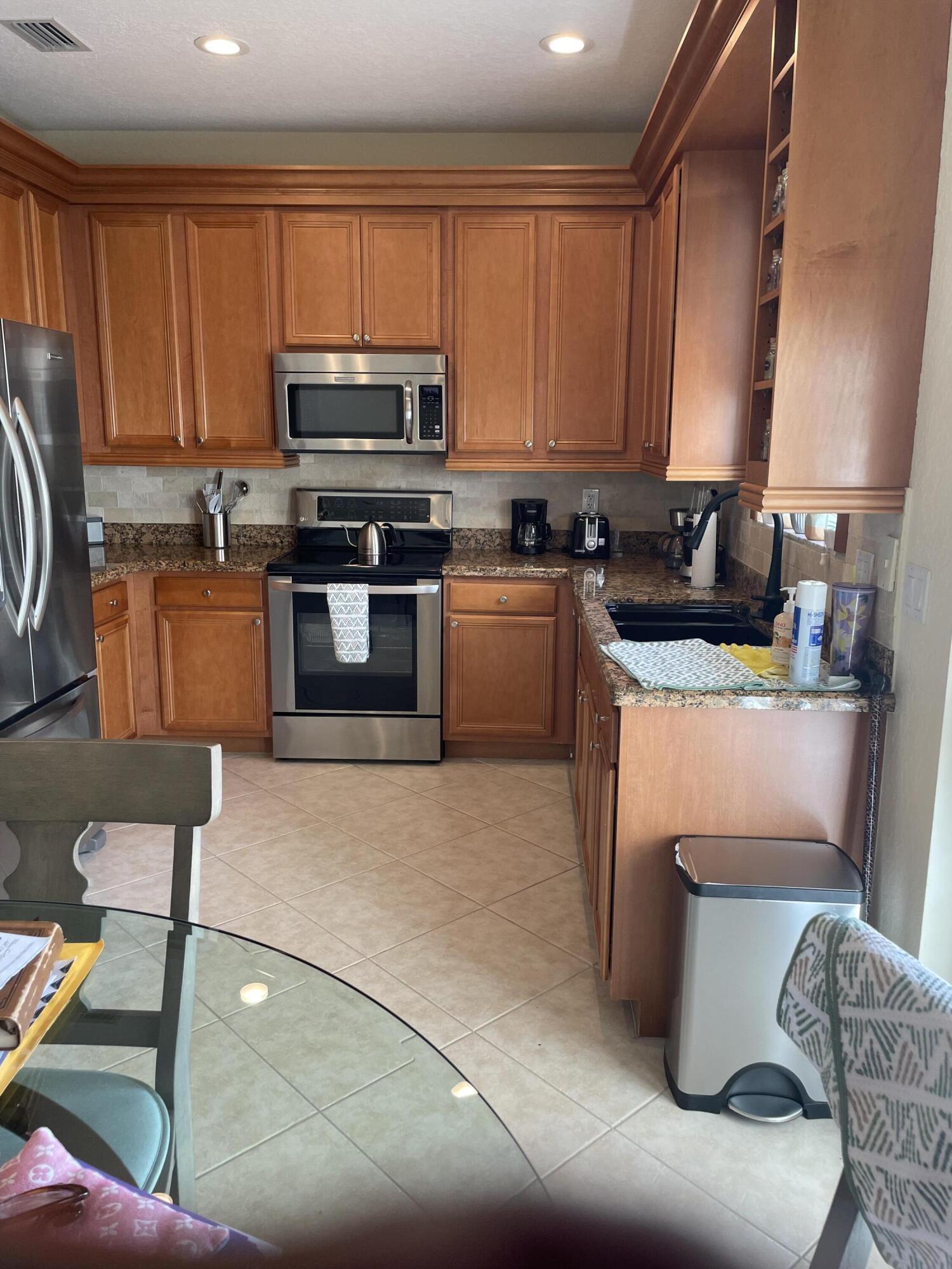 1157 Northwest 18th Avenue Boca Raton, FL 33431 - Photo 12 of 22 a kitchen with stainless steel appliances granite countertop a stove a sink a microwave a refrigerator and cabinets