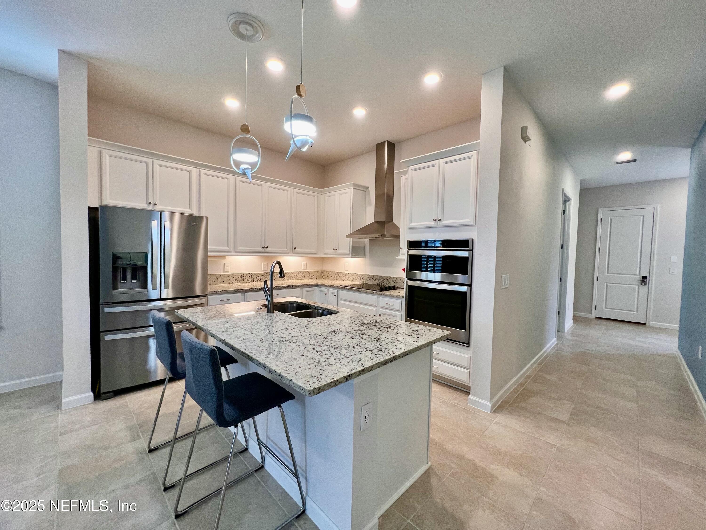 3274 Bailey Ann Drive Ormond Beach, FL 32174 - Photo 12 of 46 a kitchen with kitchen island a refrigerator stove a sink and a oven