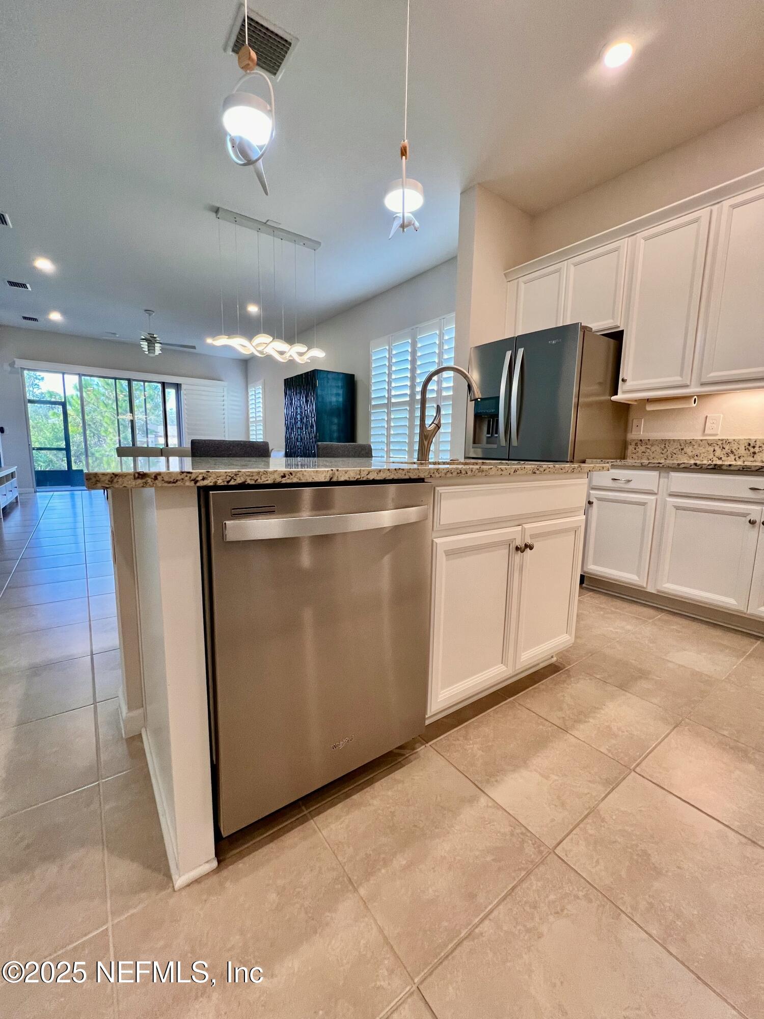 3274 Bailey Ann Drive Ormond Beach, FL 32174 - Photo 7 of 46 a kitchen with stainless steel appliances granite countertop a stove top oven a sink a refrigerator and white cabinets