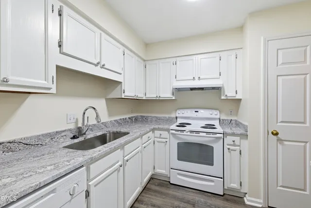 a kitchen with cabinets appliances a sink and a counter top