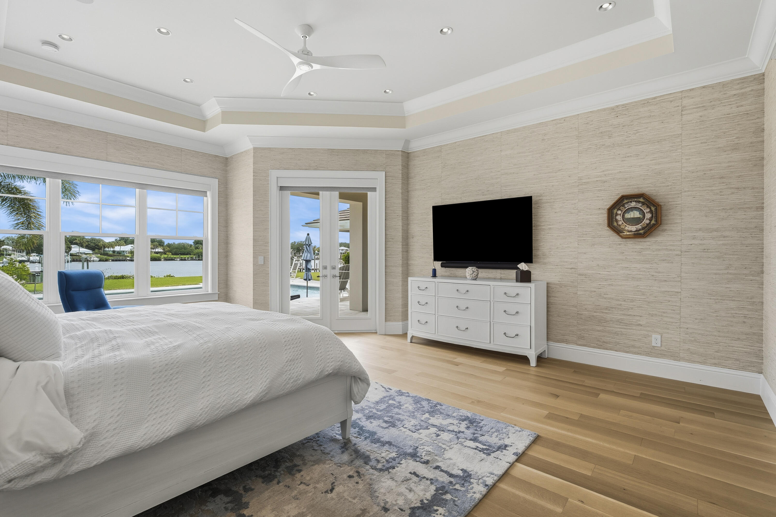 3973 Southeast Topsail Court Stuart, FL 34997 - Photo 25 of 38 a living room with a flat screen tv a rug and a floor to ceiling window