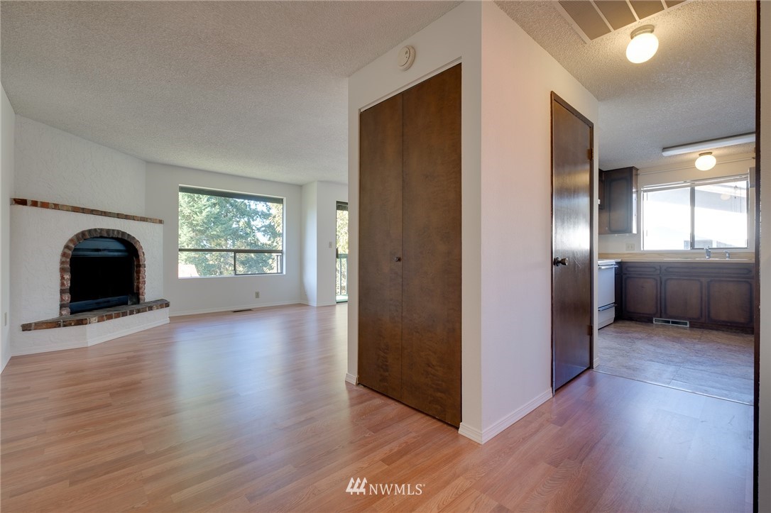 709 Sheridan Road Bremerton, WA 98310 - Photo 4 of 19 an empty room with wooden floor cabinet and windows