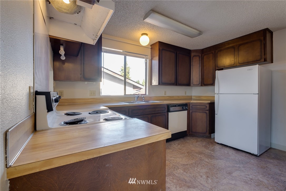 709 Sheridan Road Bremerton, WA 98310 - Photo 8 of 19 a kitchen with a refrigerator a stove a sink and a microwave