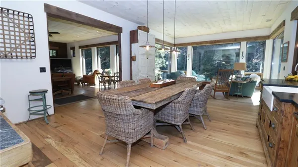 a dining room with furniture large windows and wooden floor