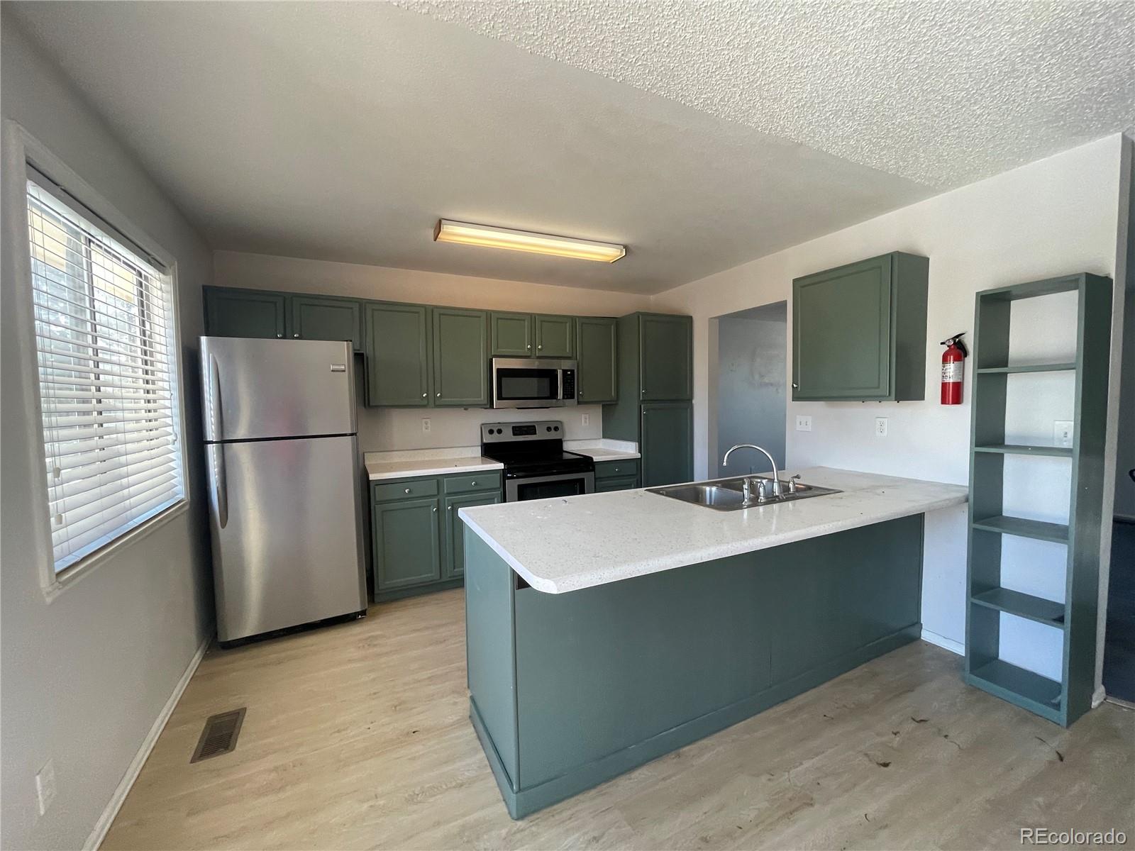2955 Quincy Place Colorado Springs, CO 80916 - Photo 2 of 33 a kitchen with stainless steel appliances a refrigerator sink and microwave