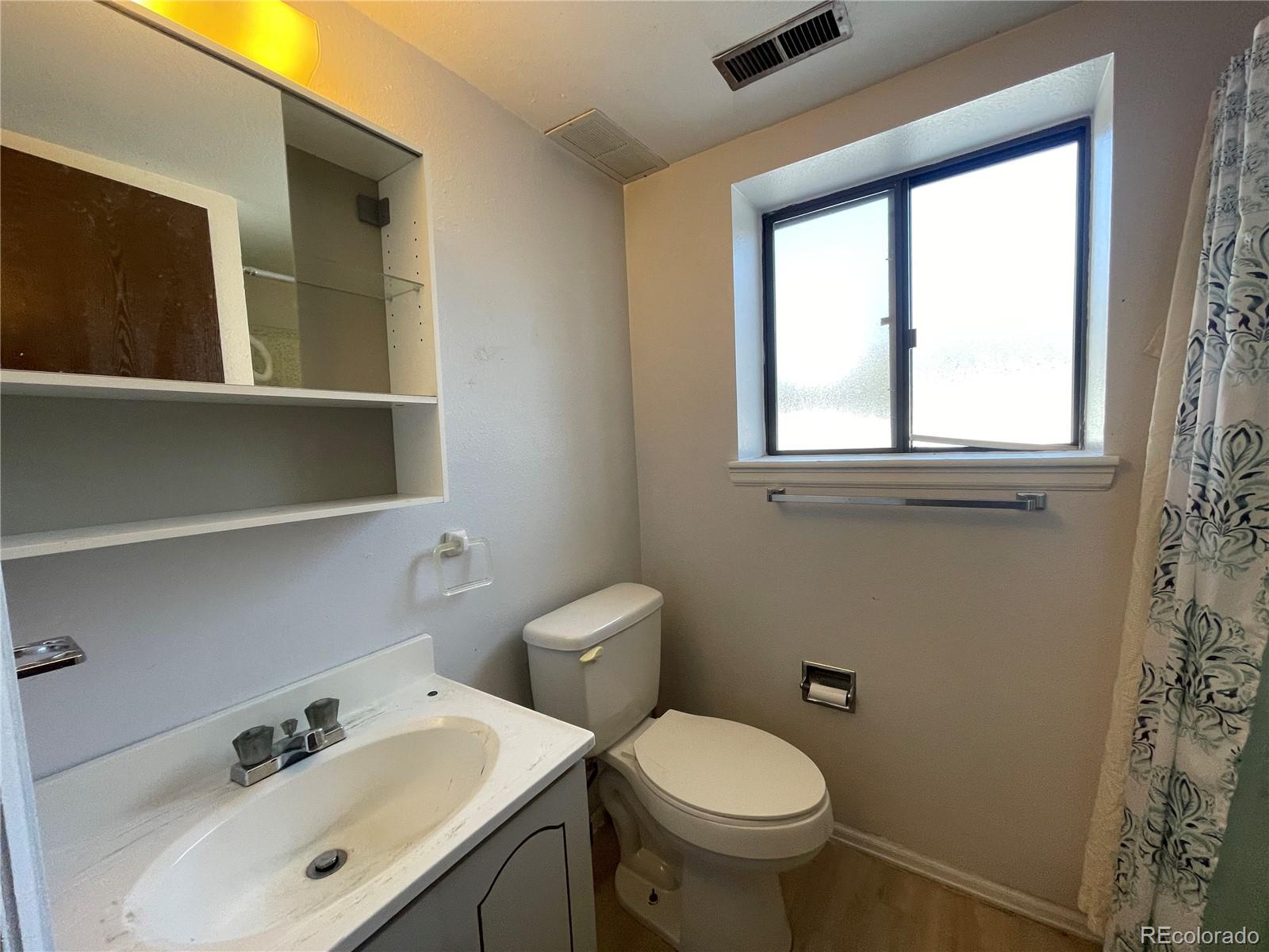 2955 Quincy Place Colorado Springs, CO 80916 - Photo 22 of 33 a bathroom with a sink mirror and toilet