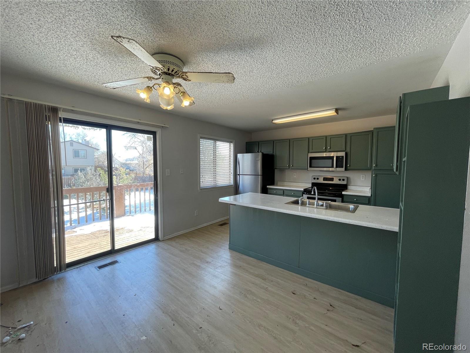 2955 Quincy Place Colorado Springs, CO 80916 - Photo 4 of 33 a view of kitchen with sink a refrigerator and a view of living room