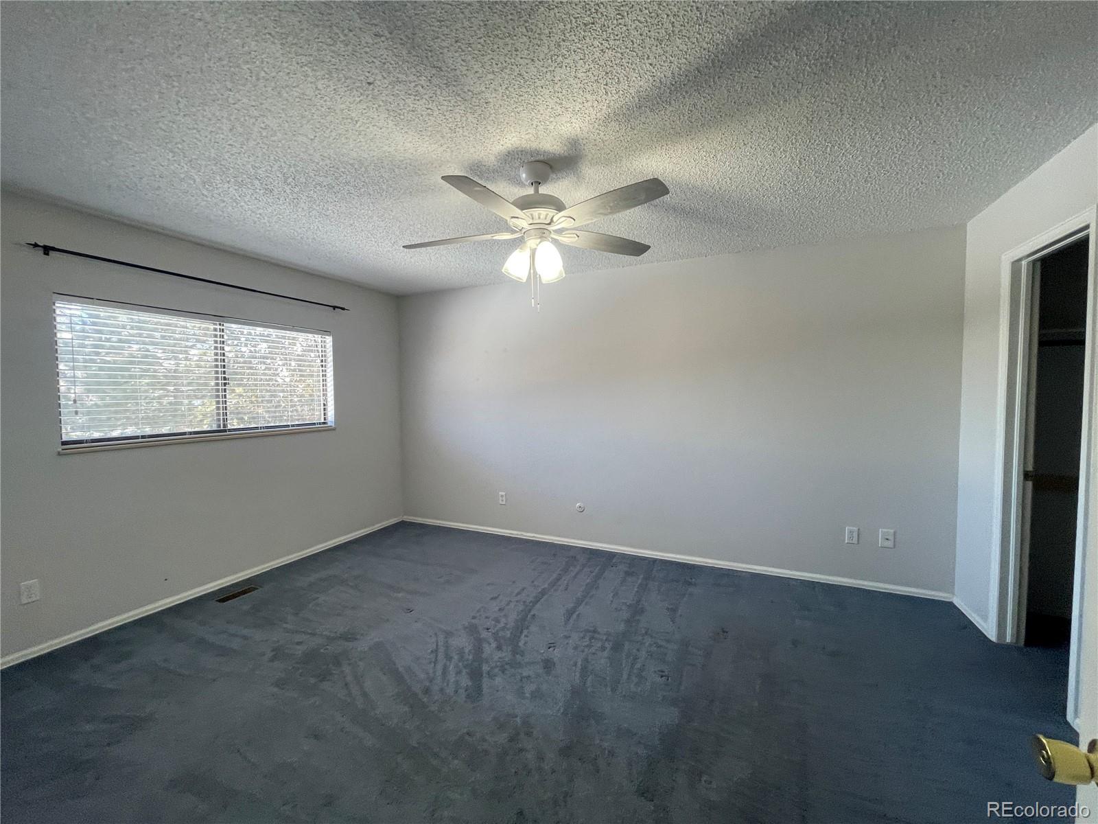 2955 Quincy Place Colorado Springs, CO 80916 - Photo 8 of 33 an empty room with windows and fan