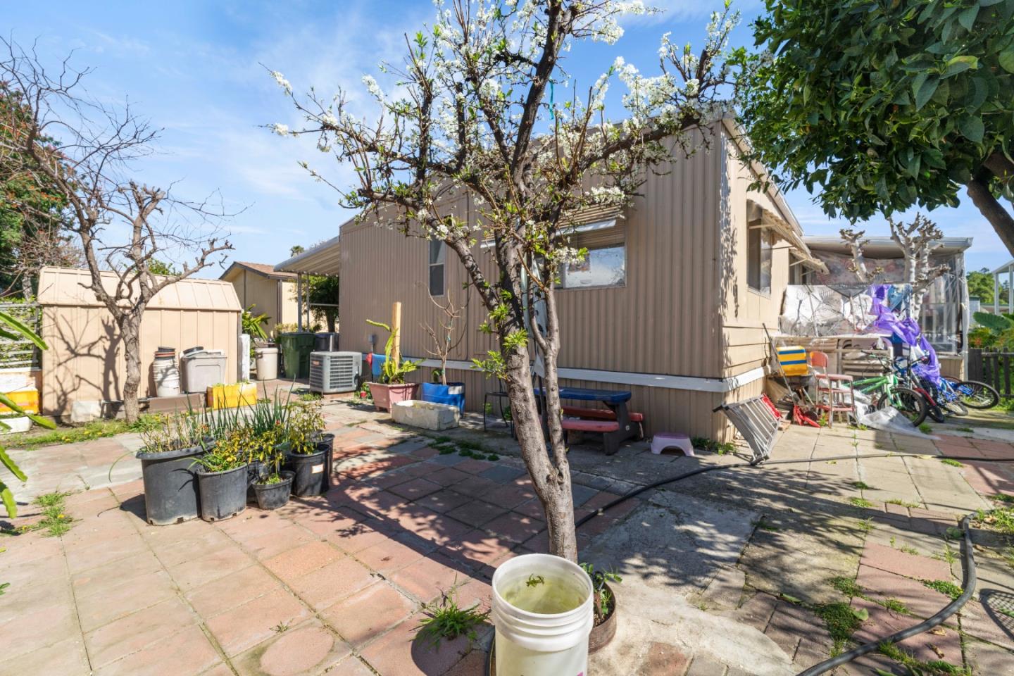 5450 Monterey Road, Unit 157 San Jose, CA 95111 - Photo 23 of 30 a view of a patio with table and chairs potted plants and large tree