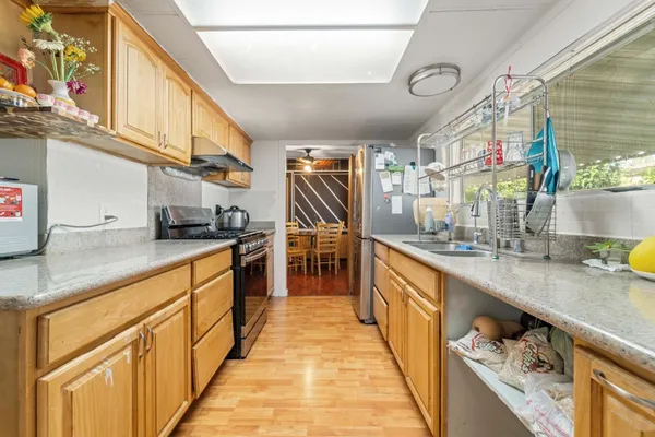 a kitchen with stainless steel appliances granite countertop a refrigerator a stove and a sink