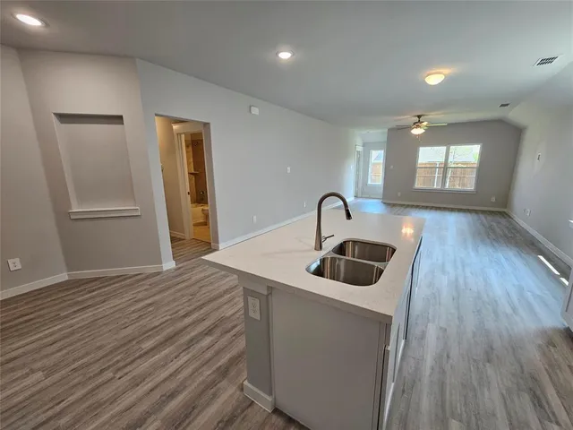 a kitchen with a sink and wooden floor