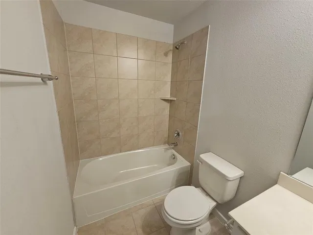 a white toilet and tub sitting next to a bathroom sink