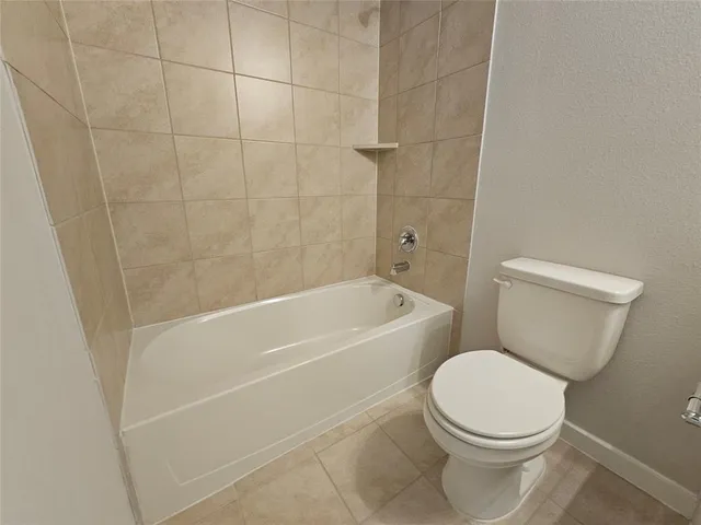 a white toilet sitting next to a bath tub