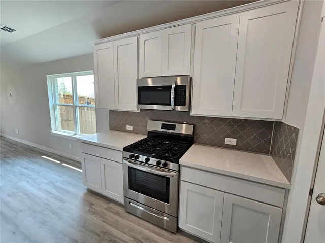 a kitchen with appliances a sink and a stove