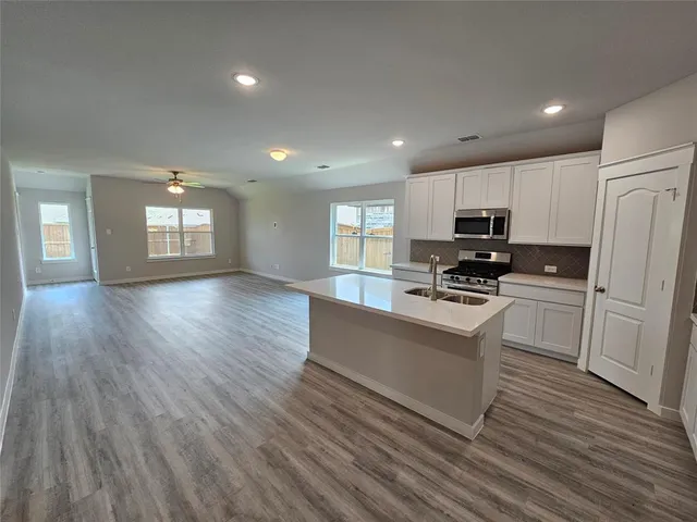 a kitchen with stove cabinets and wooden floor