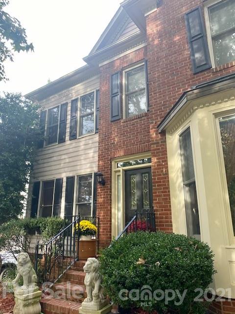 7923 Harrington Woods Road Charlotte, NC 28269 - Photo 2 of 15 front view of a brick house with large windows and a table