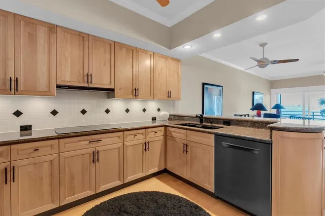 a kitchen with white cabinets sink and dishwasher