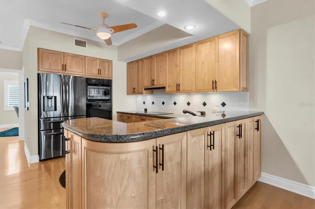 a kitchen with stainless steel appliances granite countertop a sink and a refrigerator