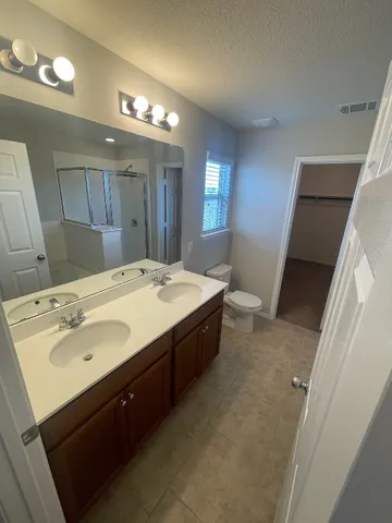 a spacious bathroom with a double vanity sink and a mirror