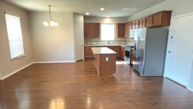 a kitchen with kitchen island a counter top space a sink appliances and cabinets