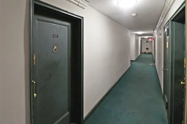 a view of a hallway with wooden floor and a living room