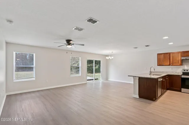 a view of kitchen with granite countertop cabinets and wooden floor