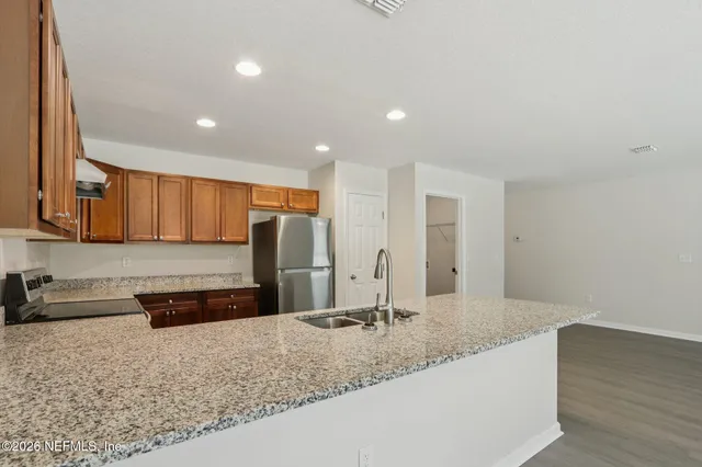 a large kitchen with kitchen island a sink stainless steel appliances and a counter space