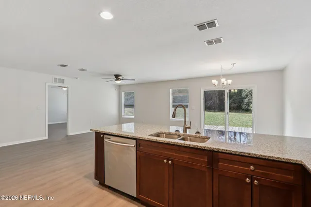 a bathroom with a granite countertop sink a large mirror and a window