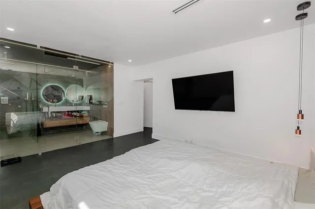 a bedroom with a bed and a flat screen tv