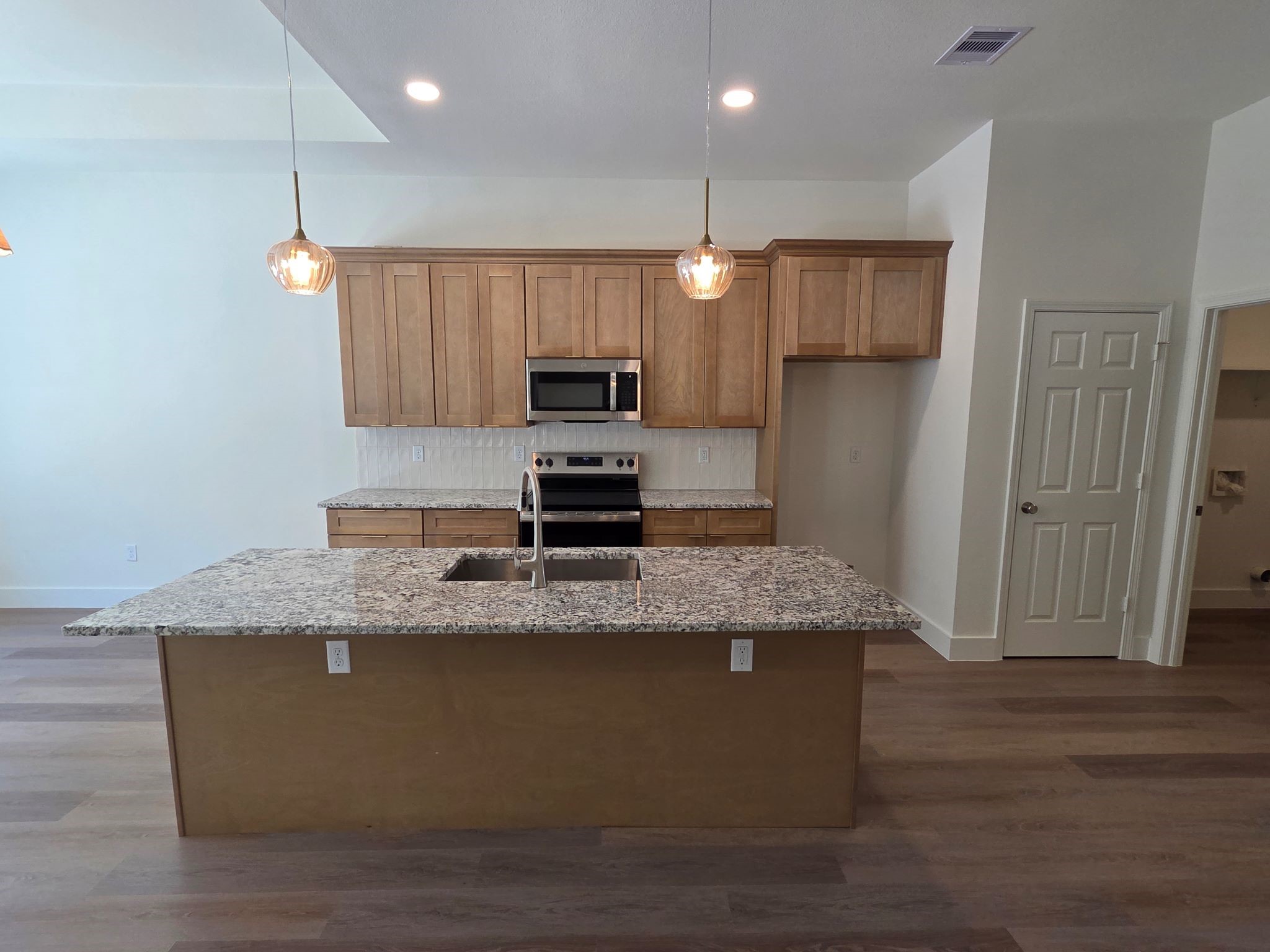 16280 Jeet Street Conroe, TX 77306 - Photo 11 of 31 a kitchen with kitchen island granite countertop a sink a center island stainless steel appliances and cabinets