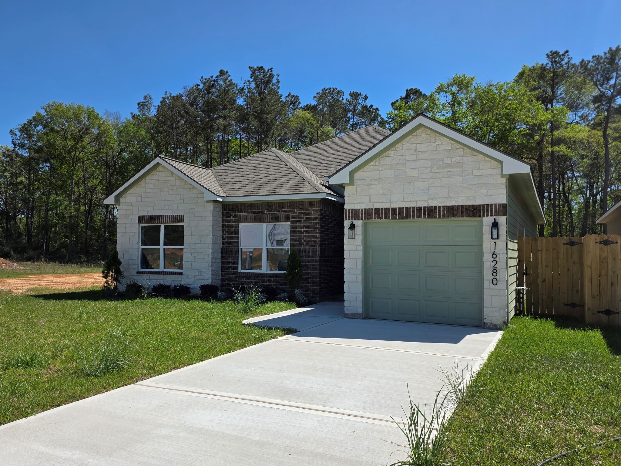 16280 Jeet Street Conroe, TX 77306 - Photo 2 of 31 a front view of a house with a yard and garage