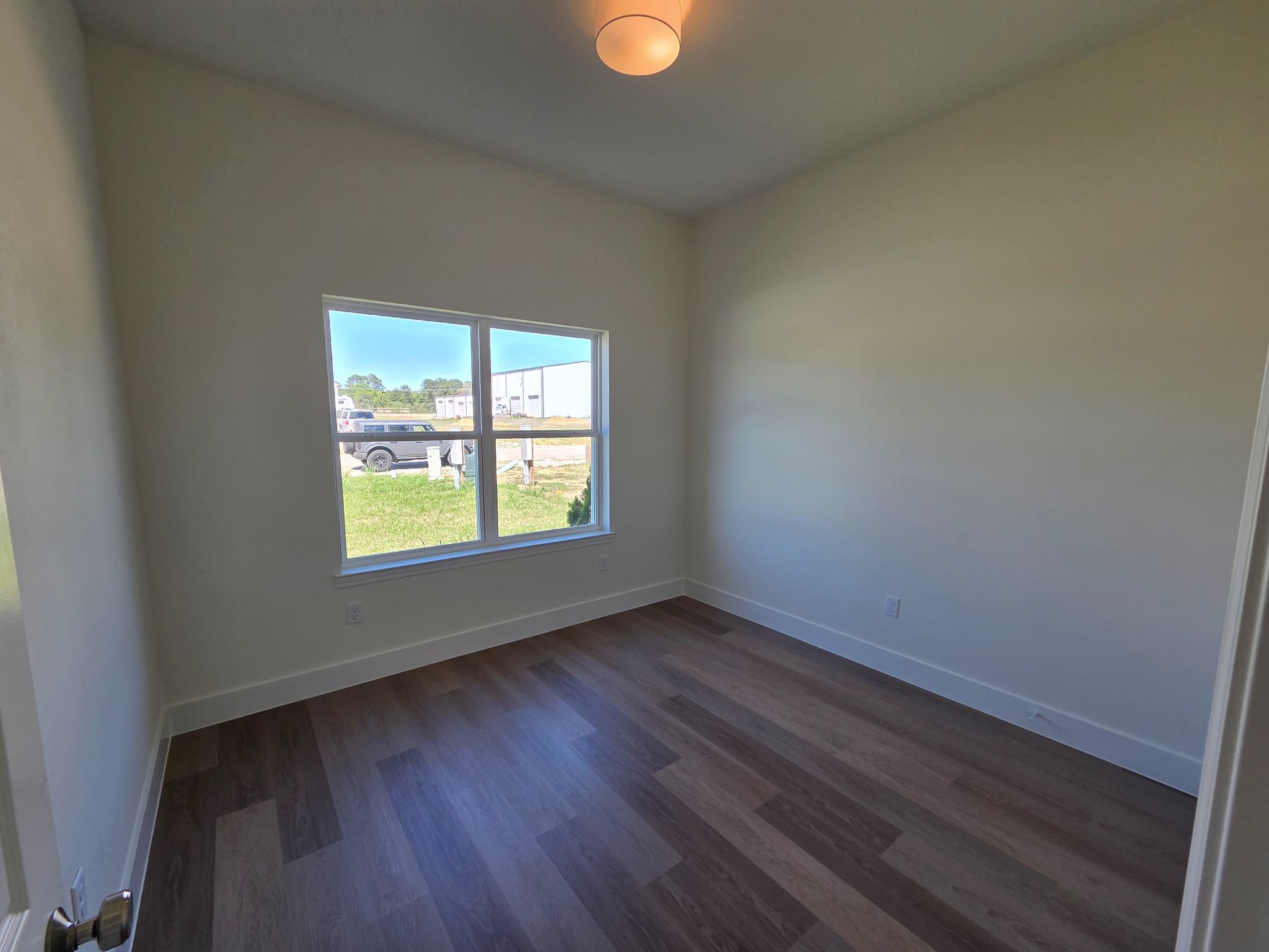 16280 Jeet Street Conroe, TX 77306 - Photo 22 of 31 an empty room with wooden floor and windows