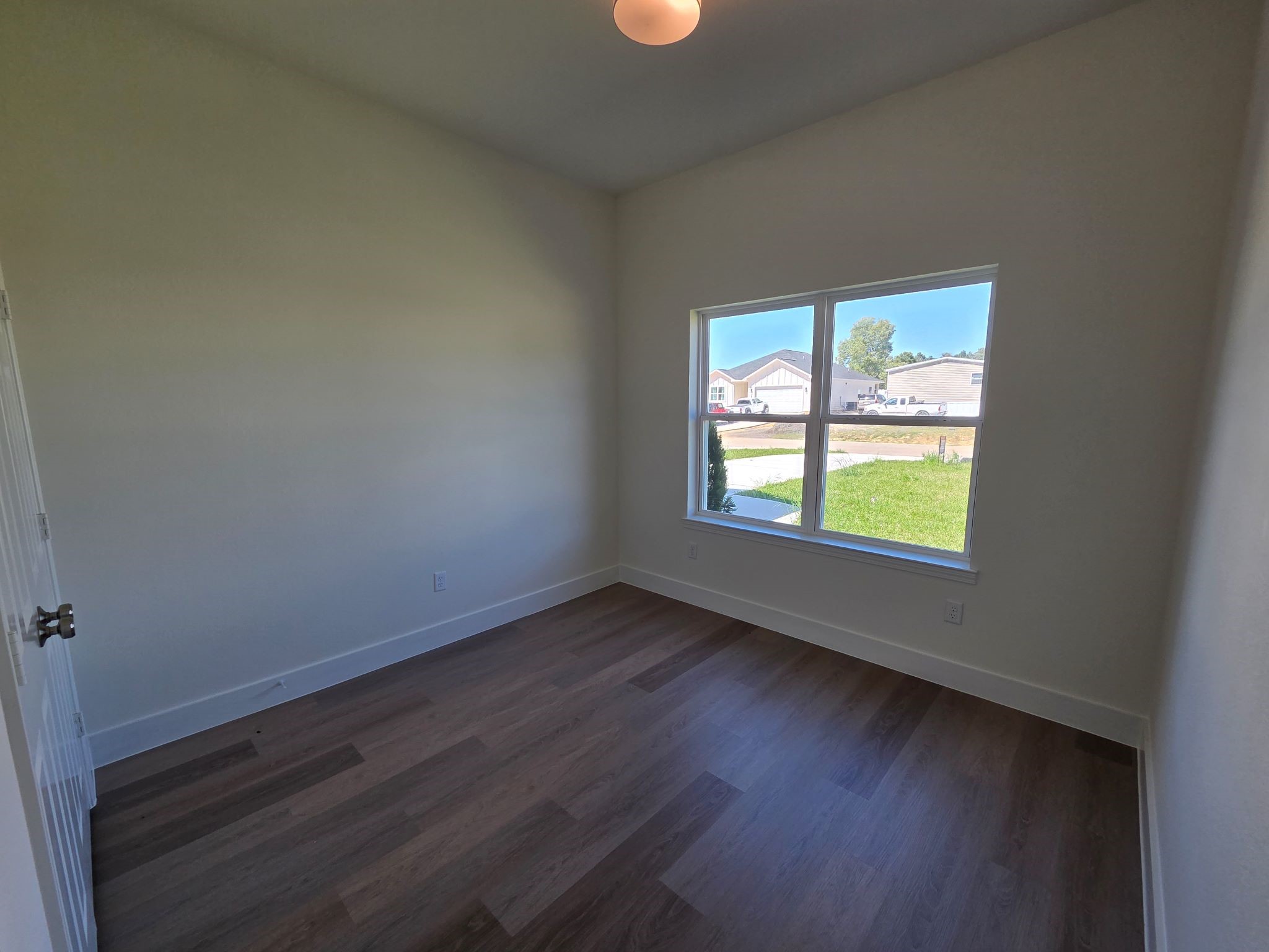 16280 Jeet Street Conroe, TX 77306 - Photo 24 of 31 an empty room with wooden floor and windows