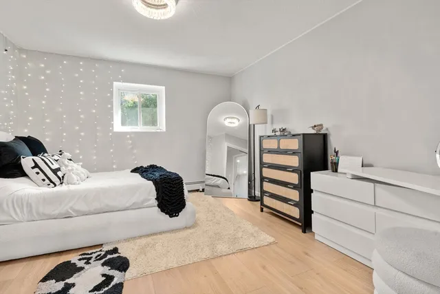 a bedroom with a bed and a lamp on dresser