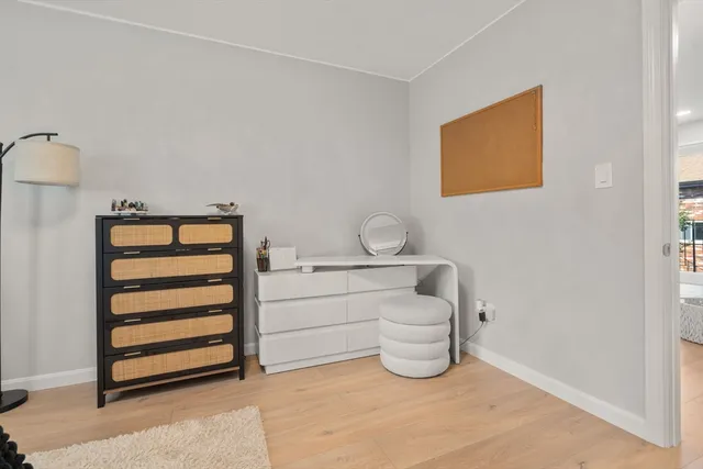 a room with a baby crib and dresser