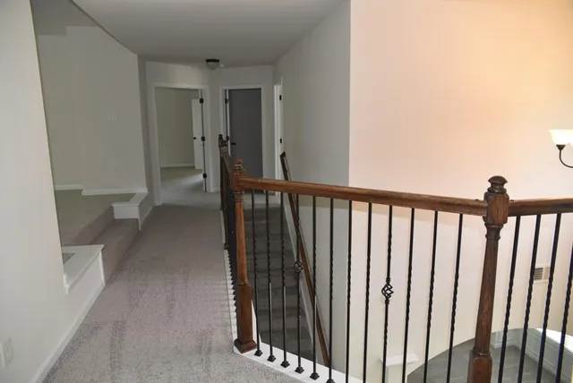 a view of a hallway with wooden floor and staircase