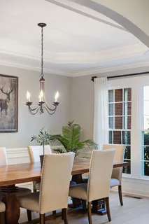 a dining room with furniture a chandelier and wooden floor